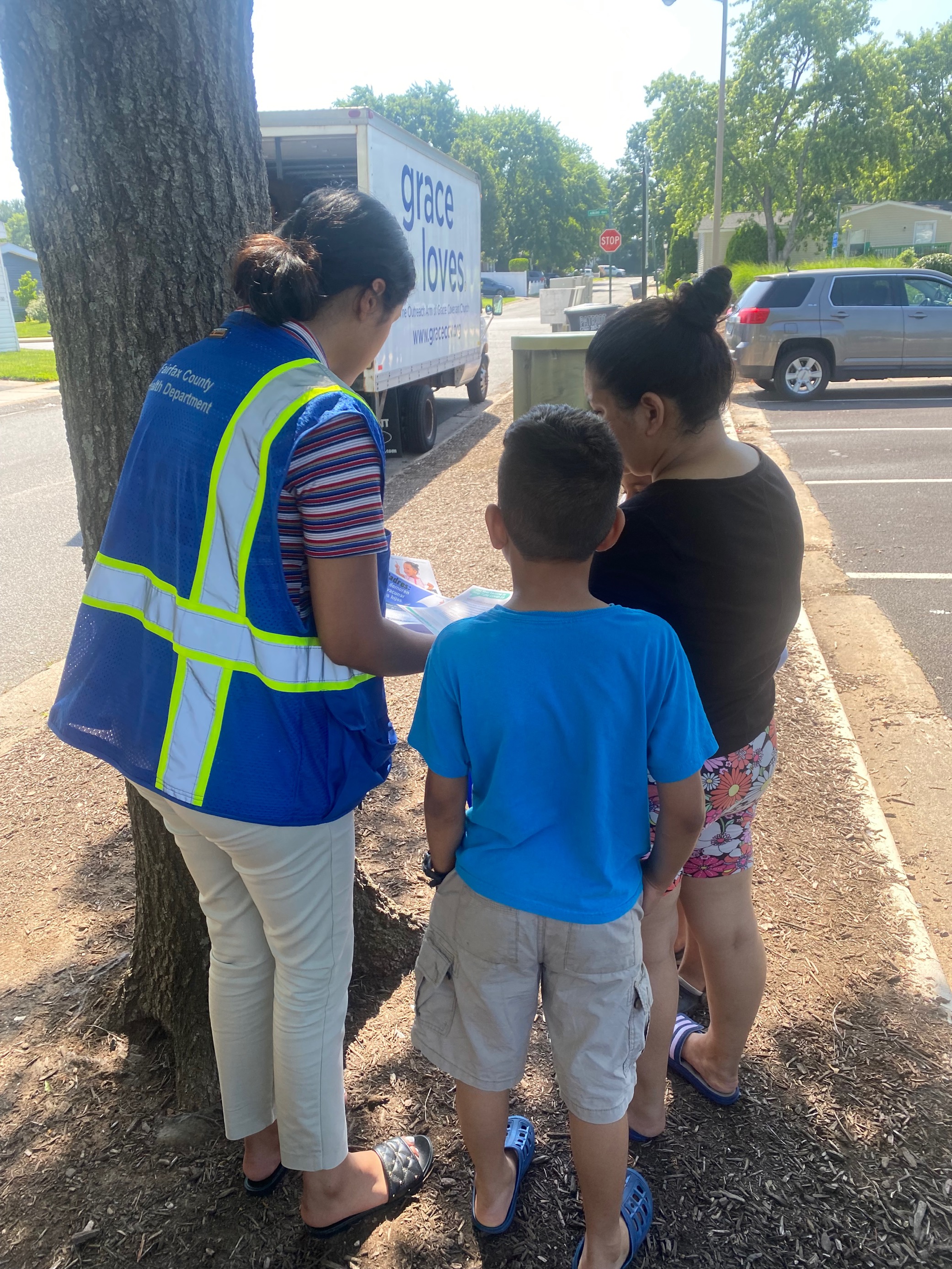 Community health worker assisting people at food distribution event