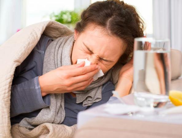 Sick person in bed sneezing