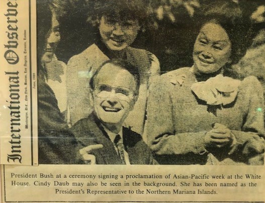 Black and white newspaper clipping of a photo of people with text below it