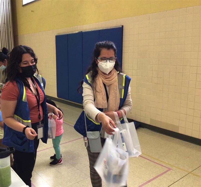 Community health workers handing out bags of food