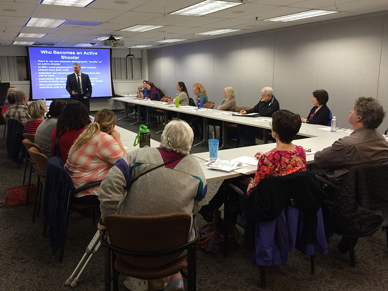 MRC volunteer seated in a conference room listening to a presentation