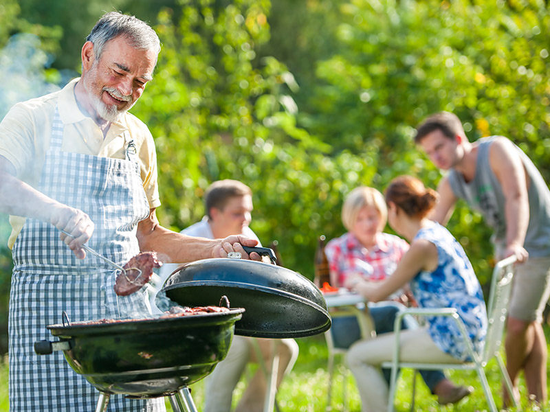 Man turning burger with tongs on the grill