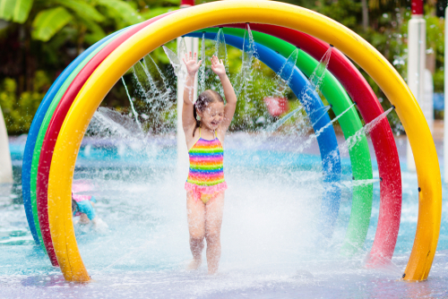 A young girl plays joyfully at a splashpad