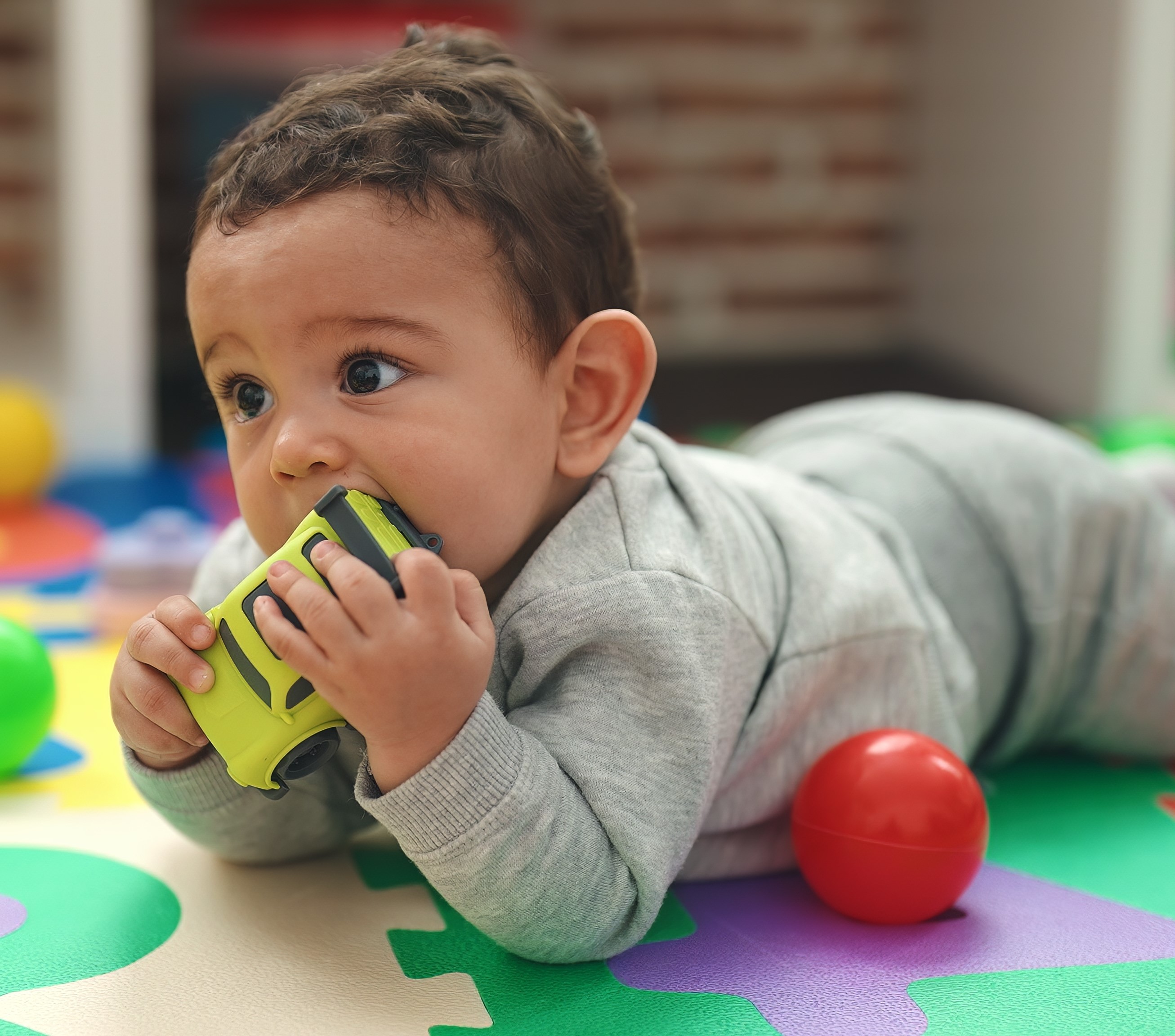 Baby chewing on toy