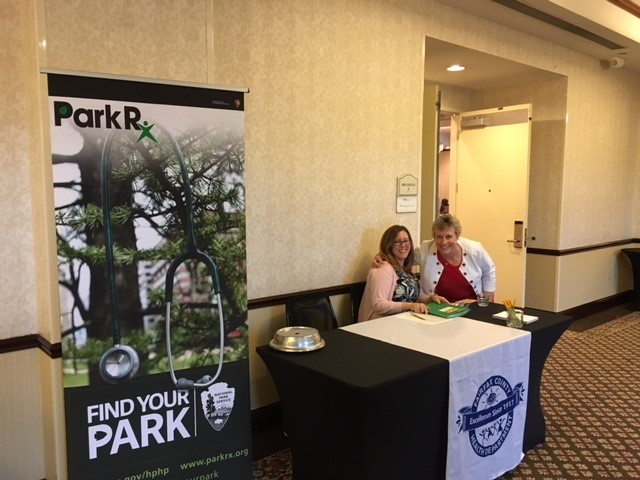 Two Health Department staff members at Rx for Life conference registration desk