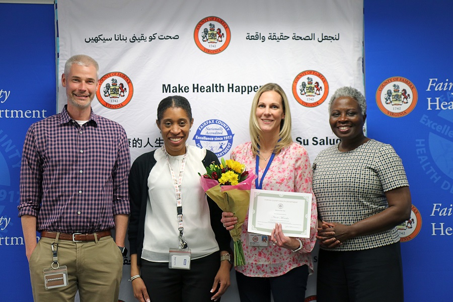 Nicole Morales receives the Nurse of the Year award from Dr. Gloria Addo-Ayensu, Brian Hochstrasser, and Kimberly Smith.