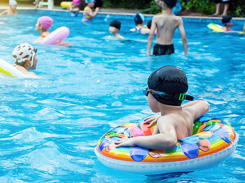 Outdoor pool with children swimming in it