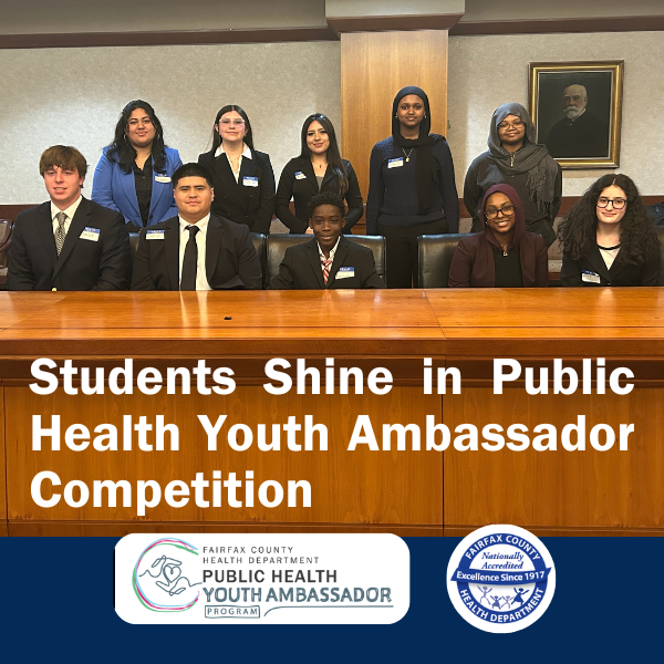 group photo of ten high school students behind a conference table