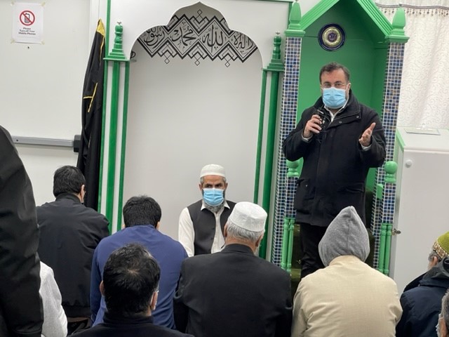 Man in a mask speaking to audience