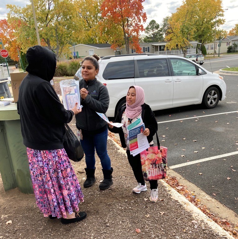 Community health workers handing out flyers at mobile food distribution