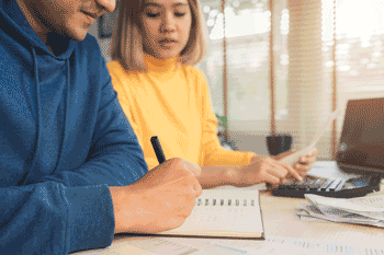 Photo of man and woman paying bills