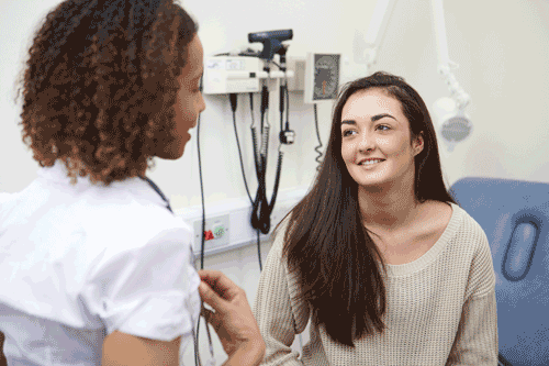 Photo of female doctor talking with teen girl