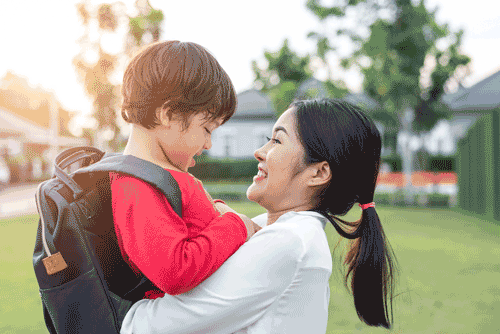 Photo of smiling mother holding preschool son