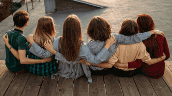 Photo of back of teens sitting on dock by skate park