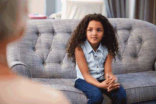 Photo of young girl talking with therapist