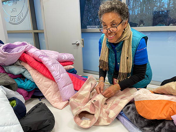 Volunteer sorting children's winter coats.