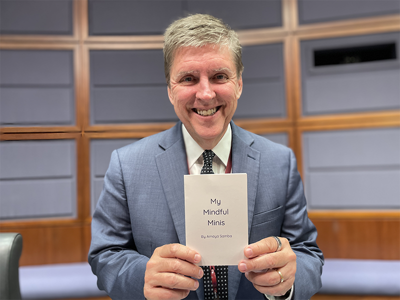 Fairfax County Supervisor Walter Alcorn holding My Mindful Minis written by Amaya Samba.