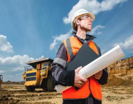 man standing on site with equipment in background