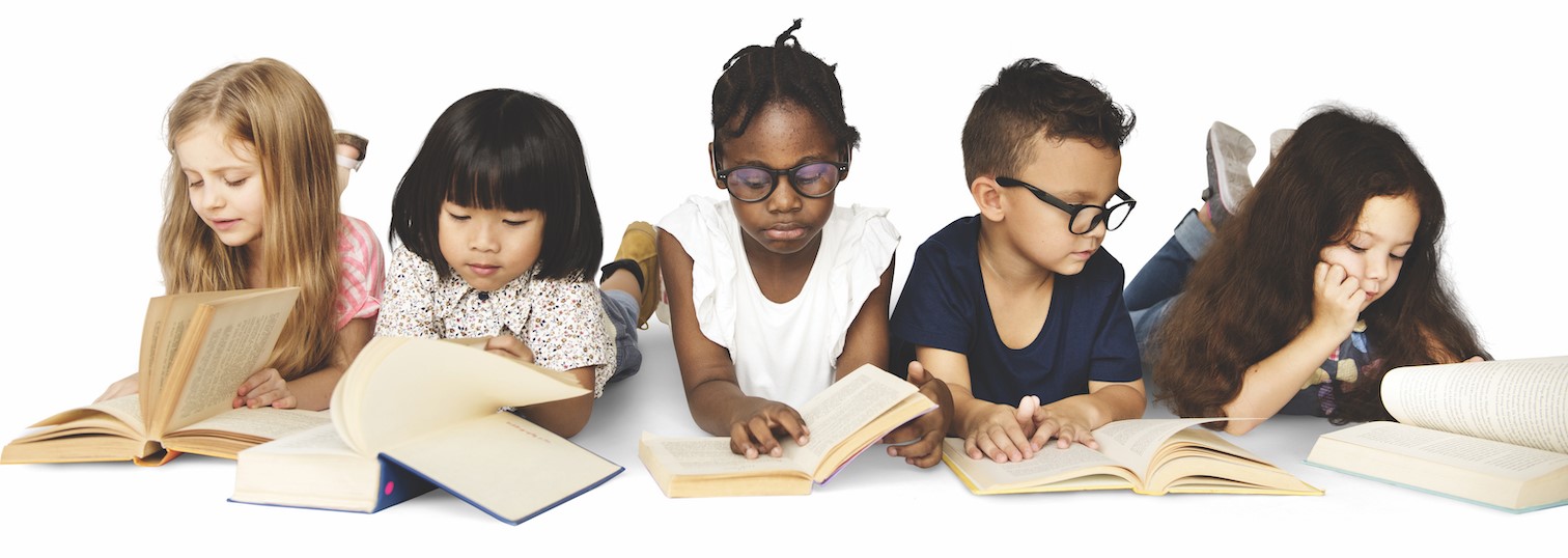 five young children of different races and ethnicities lay on their stomachs and read books