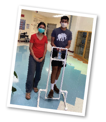 Tarun and Bhavya with one of the hands-free, foot pedal-operated hand sanitizer stations they designed and constructed.