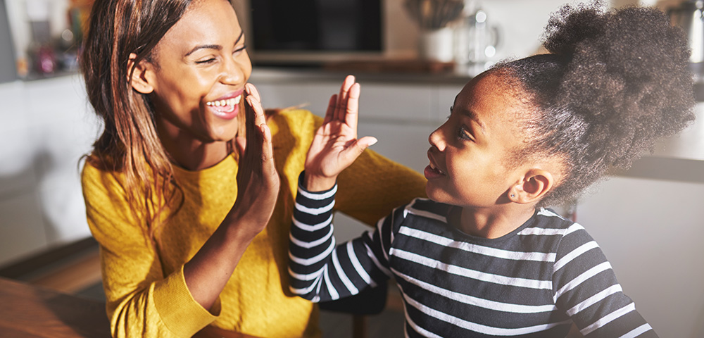 Mother and daughter give high fives.