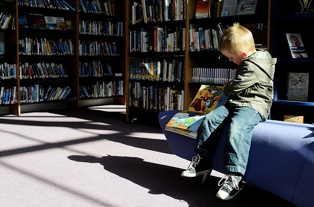 Boy reading children's book at the library