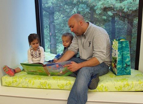 kids read with dad in a reading nook