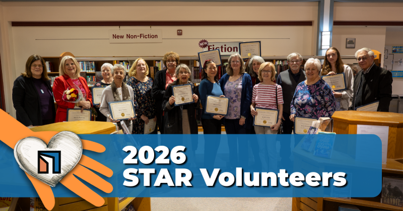 2026 Star Volunteers, photo of group of smiling people standing in the library