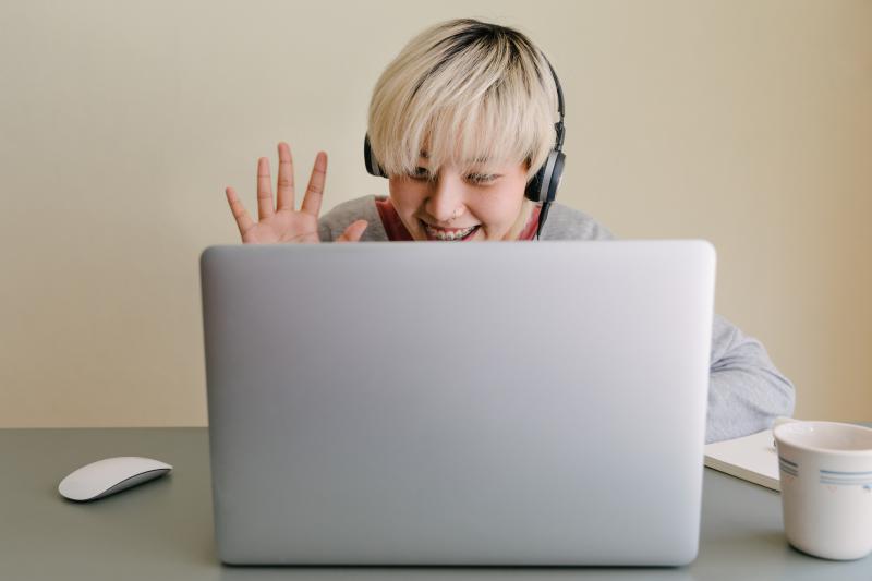 happy young woman having a video call via laptop