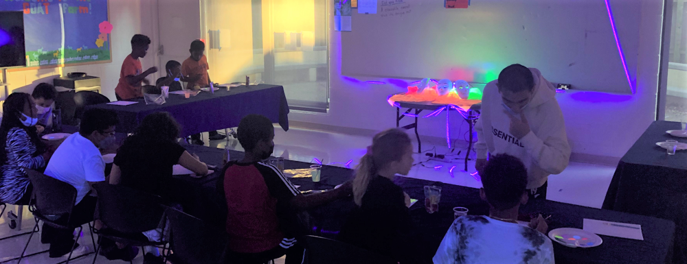 A group of students painting in a dark room