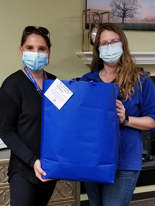 Photo of two senior center staff delivering a gift bag.