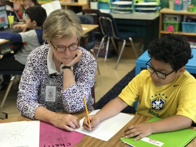 Older woman helps a student at through Grandinvolve