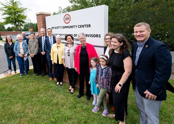 Officials and family members unveil the new Jim Scott Community Center sign 