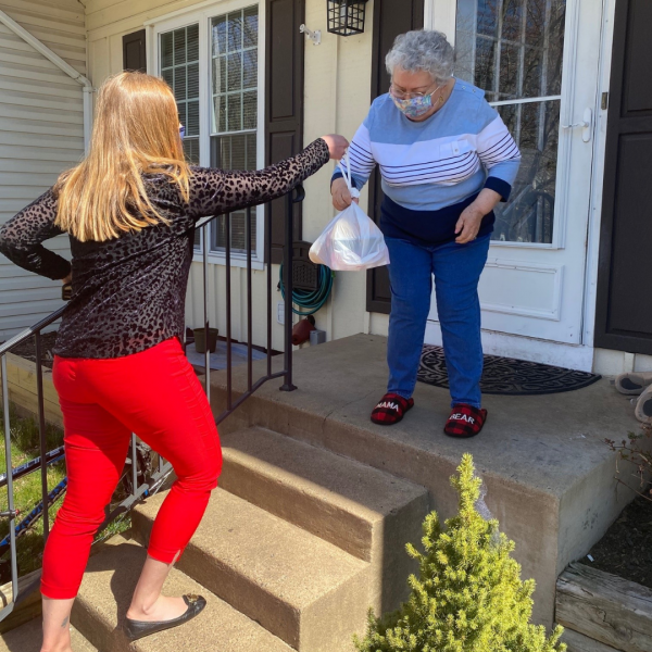 Photo of NCS staff member delivering a meal to a senior center resident.