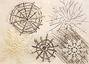 Black and white artwork depicting snowflakes using various media