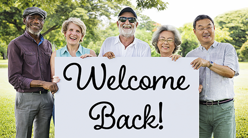 Photo of diverse seniors holding a sign that says Welcome Back.