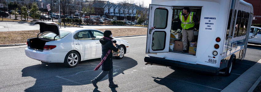 Photo of a woman donating food to Stuff the Bus.
