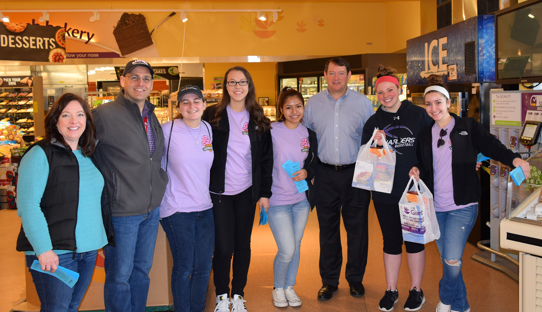 Stuff the Bus volunteers pose inside an area grocery stor.