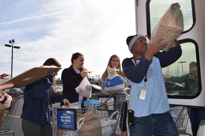 Volunteers fill a Fastran bus with food donations