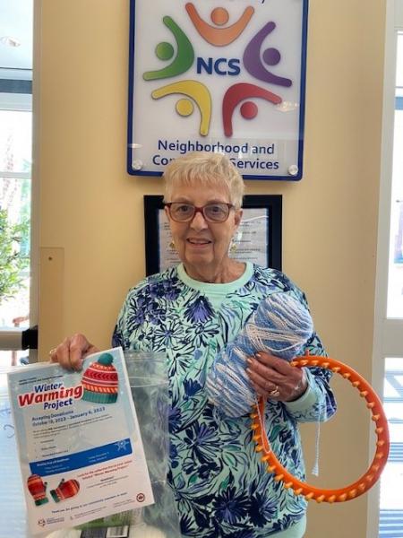 Winter Warming Project participant holds knitting loom