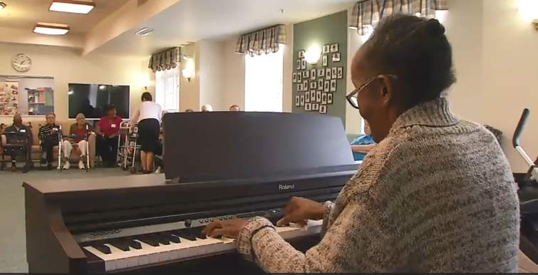 a participant plays piano to an audience
