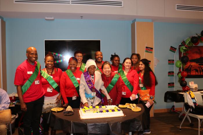 A group of staffers surround Mama Serah at her birthday celebration. 