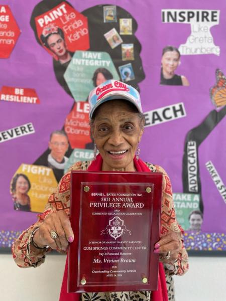 Woman in a hat holding an award