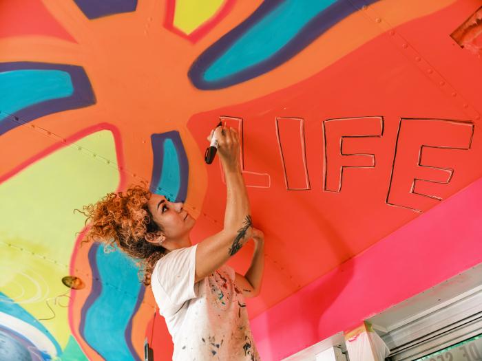 Artist creating a mural with bright colors 