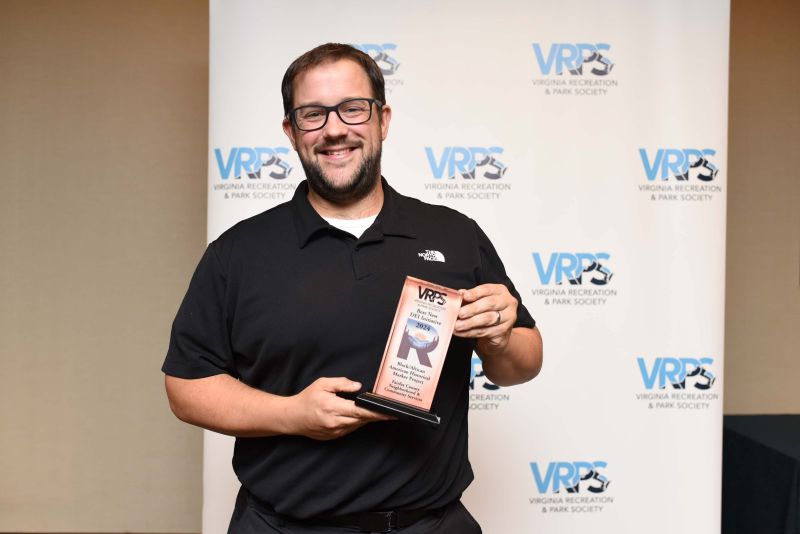 man with glasses holding award