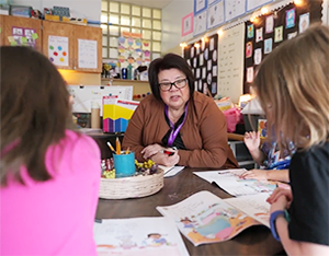 Volunteer in classroom with two kids