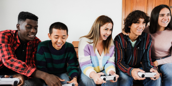 Image of a row of kids sitting on a couch holding video game controllers