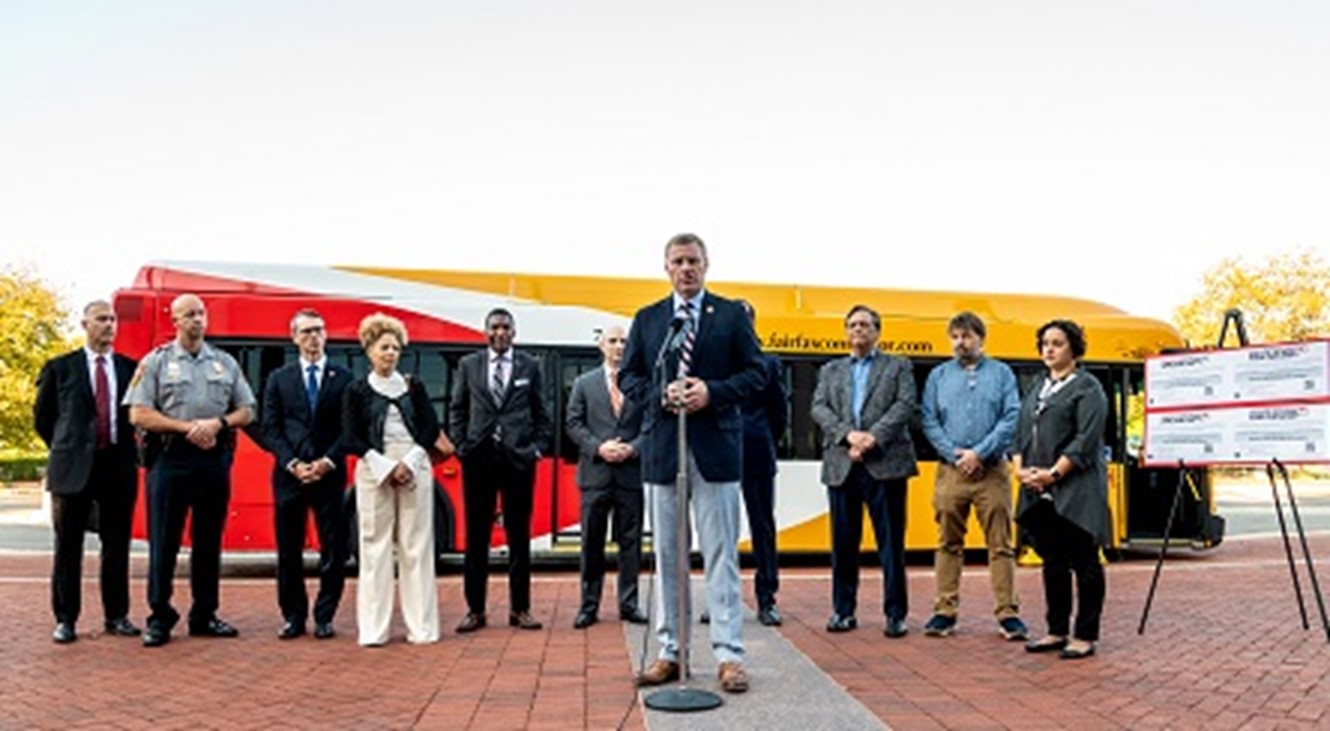 County officials stand before Connector bus with Red Flag Law advertisement