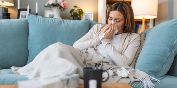 Sick person on a couch with tissues