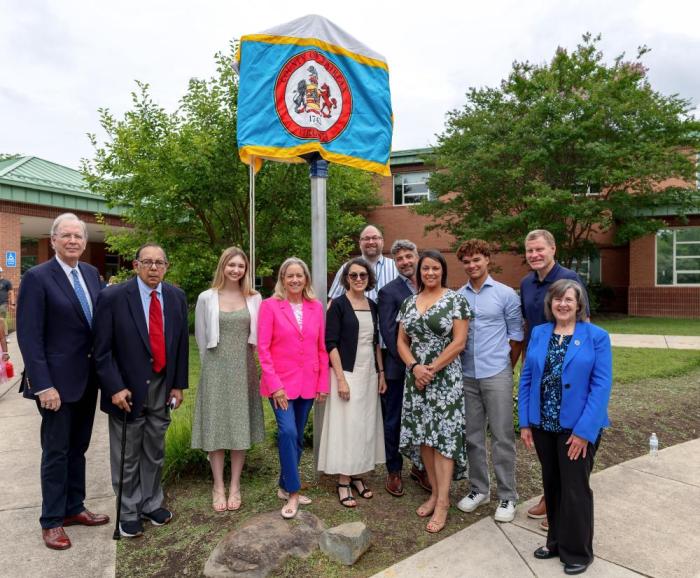 Image of residents and board members smiling in front of the covered marker.